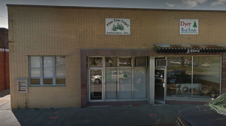 A photo of the PTLA Presque Isle office, a one-story storefront style building with a glass door